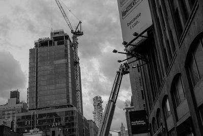 People in a construction lift working on a billboard