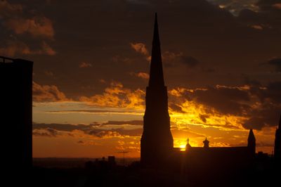 Dramatic cloudy sunset with church steeple in the distance