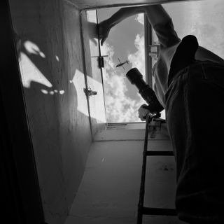 Looking up through an open roof hatch with photographer on ladder taking a picture