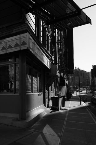 Black and white street view of the corner Watts Street and Sixth Avenue in Manhattan